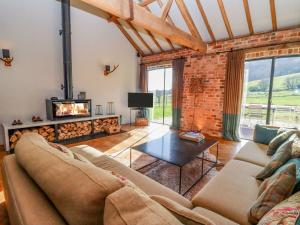 a living room with a couch and a fireplace at The Stables in Ledbury