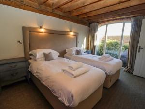 um quarto com 2 camas e toalhas em The Stables em Ledbury