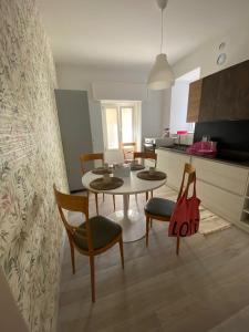 a living room with a table and chairs and a kitchen at La Chicca Maison in Vercurago