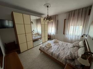 1 dormitorio con cama y baño con espejo. en Appartamento Annesca - Delta del Po, en Porto Tolle