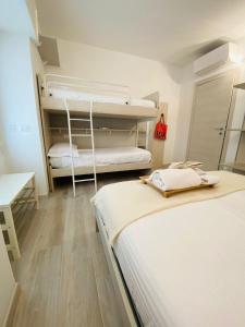 Pokój z 2 łóżkami i biurkiem oraz pokój z 2 łóżkami piętrowymi w obiekcie La Chicca Maison w mieście Vercurago