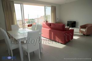 a living room with a red couch and a table and chairs at La Mojonera in Isla Plana