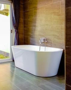 a white bath tub in a bathroom with a window at Amber Villa Malindi in Malindi