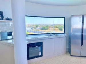eine Küche mit einem Fenster und einem Kühlschrank aus Edelstahl in der Unterkunft Apartamento con hermosa vista in Manta
