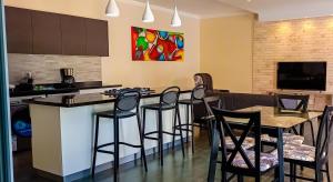 a kitchen with a bar with chairs and a counter top at Amber Villa Malindi in Malindi