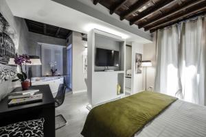 a bedroom with a bed and a desk and a television at Town House Spagna- luxury Rooms with Jacuzzi Bath in Rome