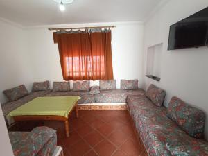 a living room with a couch and a table at Residence Family OULANTI in Martil