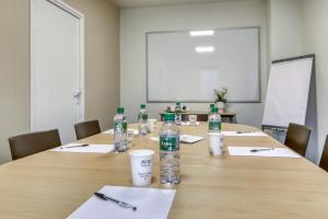 a conference room with a table with bottles of water at Ace Hôtel Clermont Ferrand La Pardieu in Clermont-Ferrand