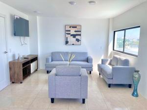 a living room with two chairs and a couch and a tv at Apartamento con hermosa vista in Manta