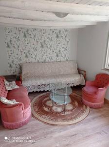 sala de estar con 2 sillas y mesa en Gîte à Noailhac ferme au calme bourg & église XII, en Noailhac