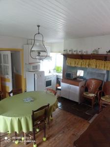 uma cozinha com uma mesa com uma toalha de mesa verde em Gîte à Noailhac ferme au calme bourg & église XII em Noailhac