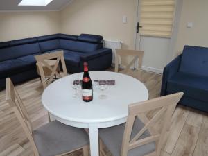 a living room with a white table and a bottle of wine at Nice holiday home in Miedzywodzie with parking in Międzywodzie