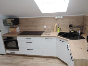 a kitchen with white cabinets and a sink at Nice holiday home in Miedzywodzie with parking in Międzywodzie