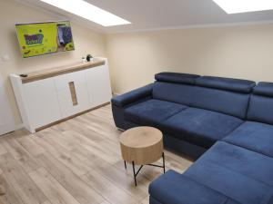 a living room with a blue couch and a table at Nice holiday home in Miedzywodzie with parking in Międzywodzie