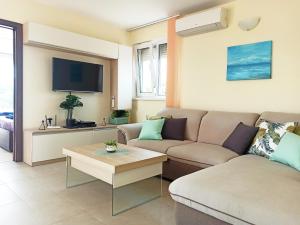 uma sala de estar com um sofá e uma televisão em Golf Villa Ariel em Kavarna