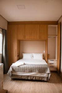 1 dormitorio con 1 cama grande y armarios de madera en Maper Ouro, en Parauapebas