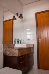 uma casa de banho com um lavatório e uma porta de madeira em Maper Ouro em Parauapebas