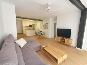 uma sala de estar com um sofá e uma televisão de ecrã plano em Junto a la playa y en el Centro Águilas - by Aloha Palma em Águilas