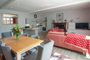 a living room and kitchen with a table and a couch at School House in Malmesbury