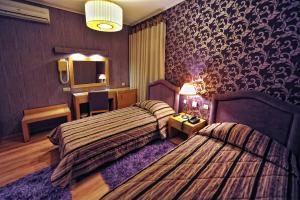 ein Hotelzimmer mit 2 Betten und einem Spiegel in der Unterkunft Haikos Hotel in Kalamata