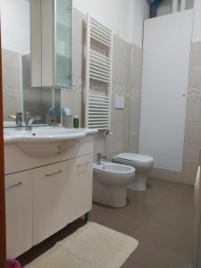 a white bathroom with a sink and a toilet at B&B Iris in Assisi