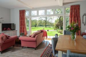 uma sala de estar com um sofá, cadeiras e uma mesa em School House em Malmesbury