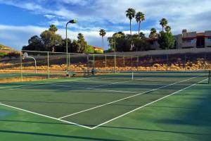 einen Tennisplatz mit Palmen im Hintergrund in der Unterkunft Poolside Condo to 1 of 3 Resort Pool-Spa Complexes, ALL HEATED & OPEN 24/7/365! in Phoenix