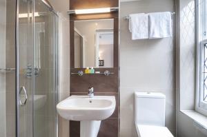uma casa de banho com um lavatório, um WC e um chuveiro em The Judd Hotel em Londres