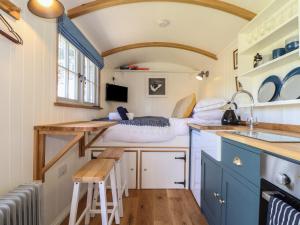 una pequeña cocina con una cama en una casa pequeña en Bosulla Shepherds Hut en Penzance