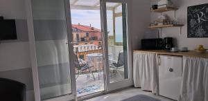 a kitchen with a sliding glass door leading to a balcony at Aa Ciasèa duu Pintùu in Riomaggiore