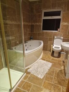 a bathroom with a tub and a toilet and a sink at Shanadune in Tralee