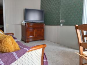 una sala de estar con TV en una cómoda de madera en Au coteau des Thermes, en Saint-Honoré-les-Bains