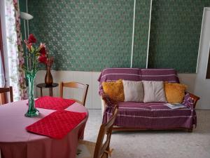 sala de estar con sofá púrpura y mesa en Au coteau des Thermes, en Saint-Honoré-les-Bains