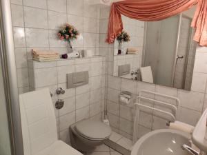 een witte badkamer met een toilet en een wastafel bij Landhaus Heide in Schneverdingen
