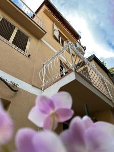 a balcony of a building with pink flowers in the foreground at ARA Home in Marcellinara