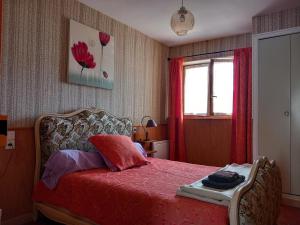 a bedroom with a bed with red sheets and a window at Au coteau des Thermes in Saint-Honoré-les-Bains