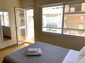 una camera da letto con un letto e due asciugamani di Boho Cruz Conde 3 a Cordoba