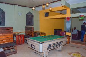 a room with a pool table and some furniture at Caphill Hotel in Syokimau
