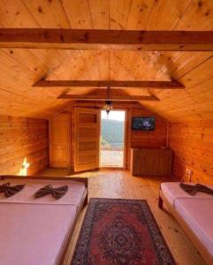 a large wooden room with two beds and a window at Vikendice Moskva Uvac in Sjenica
