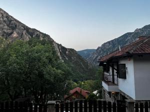 uma casa com uma cerca e montanhas ao fundo em Canyon View Lodge - Matka em Matka