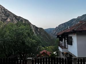 a house with a fence and mountains in the background at Canyon View Lodge - Matka in Matka