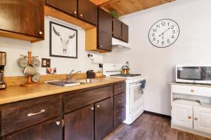 uma cozinha com um lavatório e um relógio na parede em 2299-Bear Mountain Cabin chalet em Big Bear Lake
