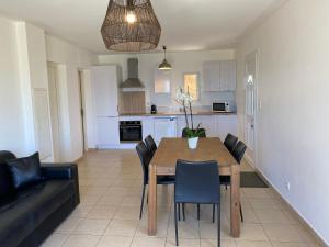 een keuken en eetkamer met een tafel en stoelen bij APPARTEMENT TERRASSE La Citadelle Appartements Saint Florent in Saint-Florent