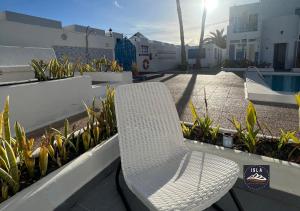 a white bench sitting on a balcony with plants at Cristian Puerto del Carmen Los Delfines in Puerto del Carmen