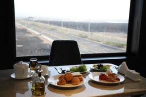 a table with plates of food and a view of a highway at فندق ايي E Hotel in Medina