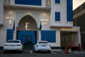 dois carros brancos estacionados em frente a um hotel em فندق ايي E Hotel em Medina