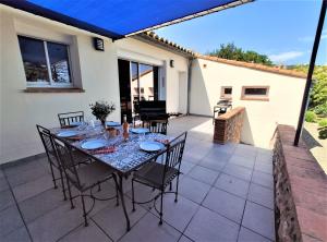 d'une terrasse avec une table et des chaises. dans l'établissement La Casa Del Pou classée 3 étoiles proche Céret et Thuir Terrain 800m2 Parking privé, à Llauro