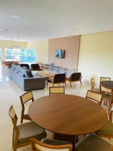 um quarto com um sofá, mesas e cadeiras em Maper Ouro em Parauapebas