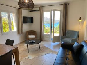 聖弗洛朗的住宿－APPARTEMENT TERRASSE La Citadelle Appartements Saint Florent，客厅配有沙发和桌子