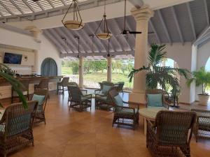 a lobby with chairs and tables and a bar at Royal Westmoreland - Royal Apartment 214 by Island Villas in Saint James